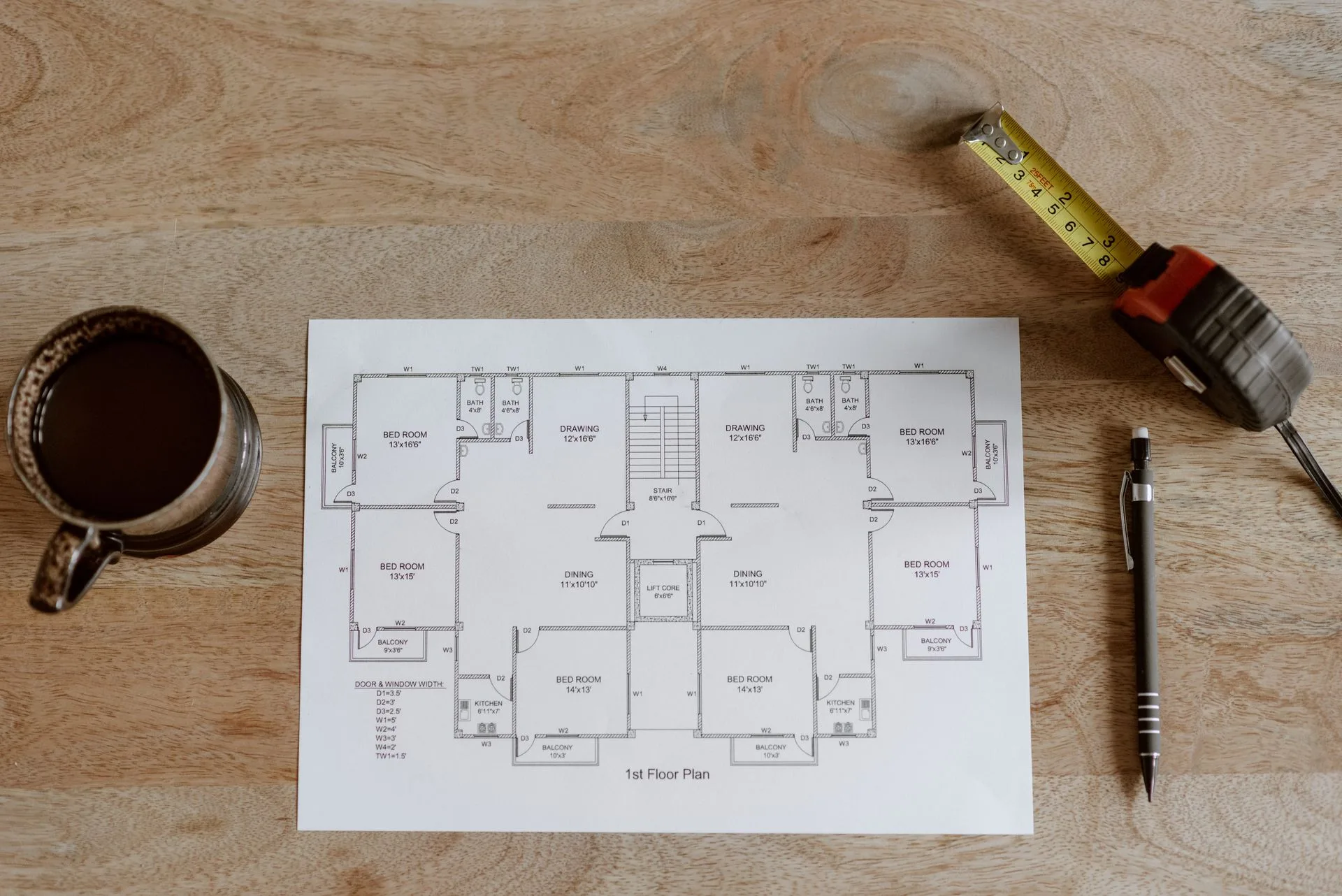 Renovation floor plan with a tape measure and pen on a timber table